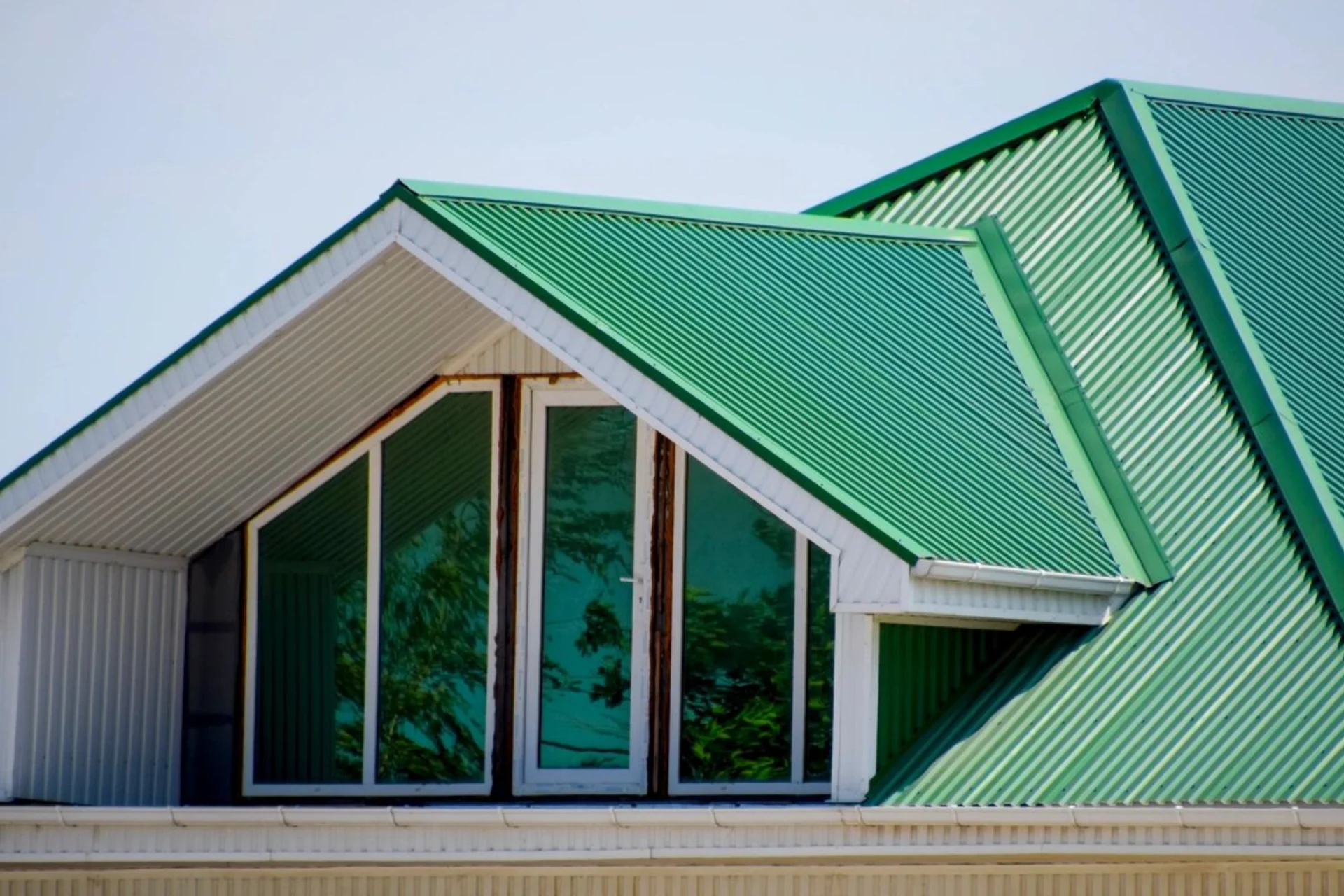 A green roof with windows and doors on top of it.