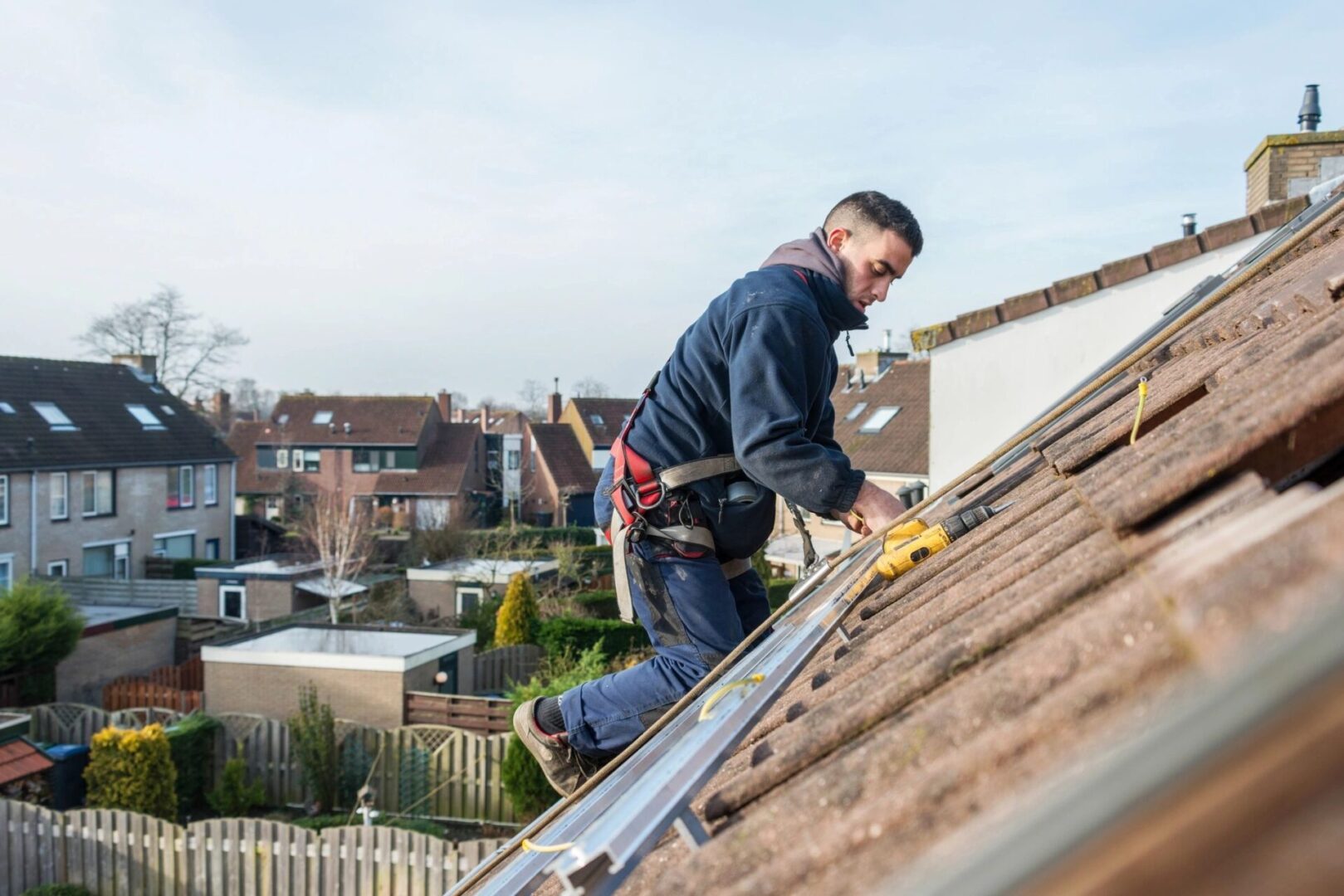 A man on the roof of his house working.