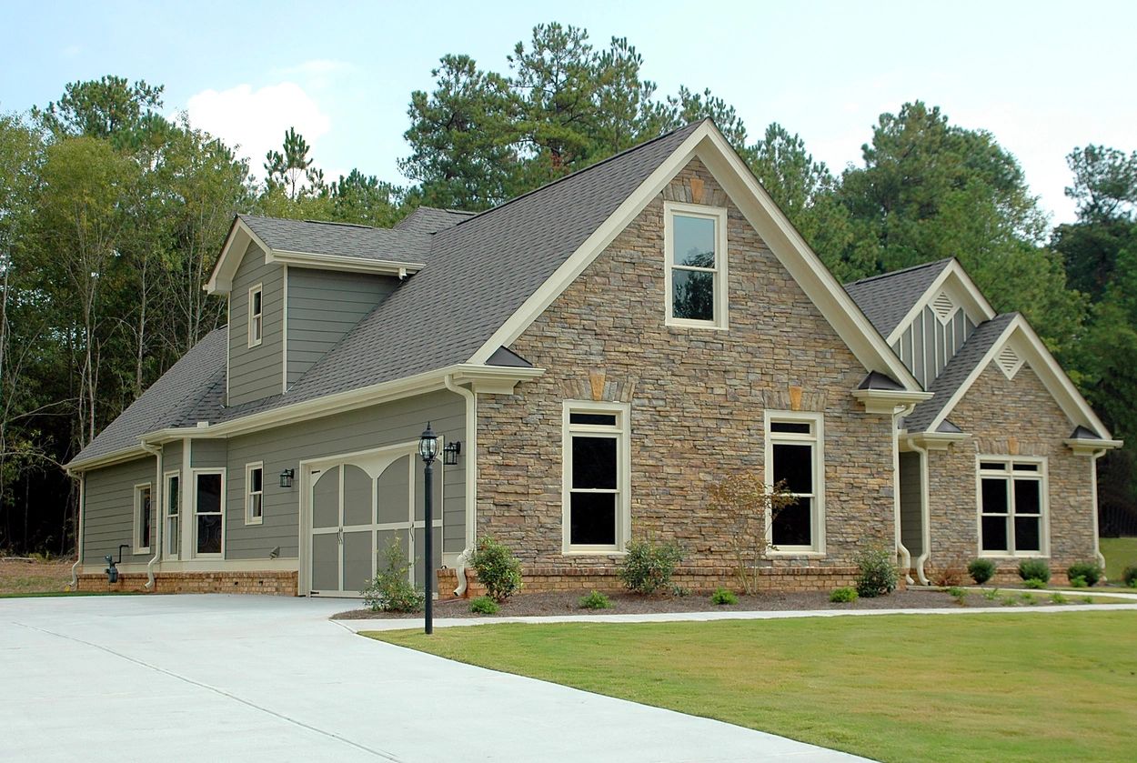 A house with a driveway and trees in the background.