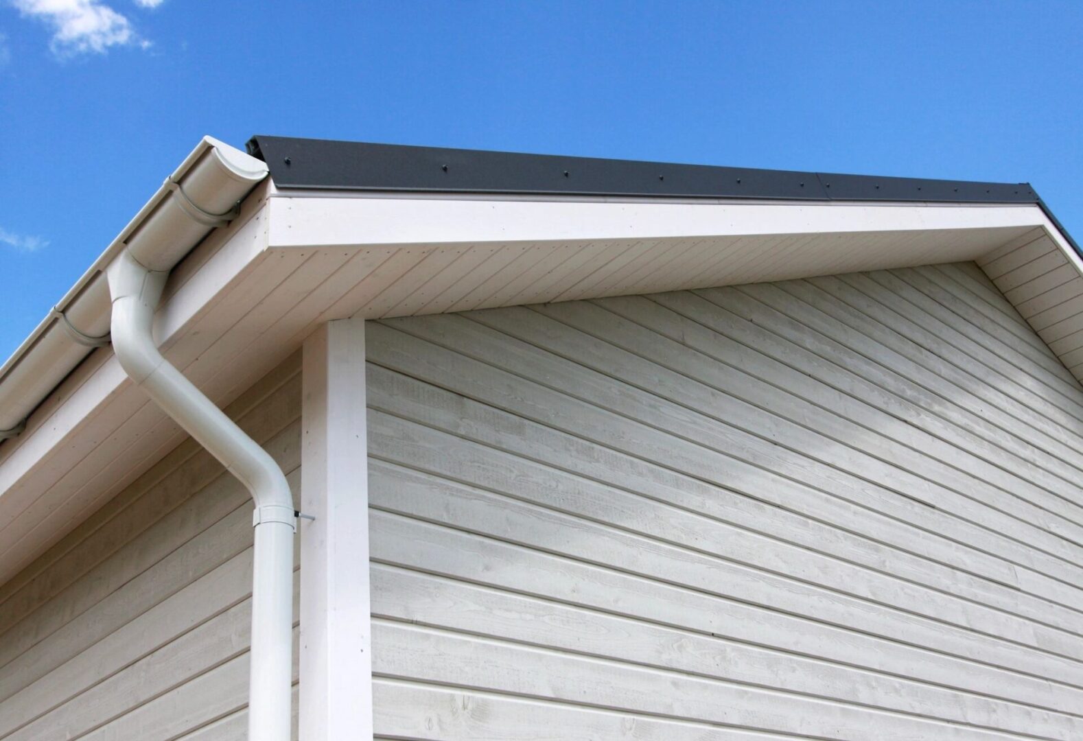 A close up of the side of a house with a gutter