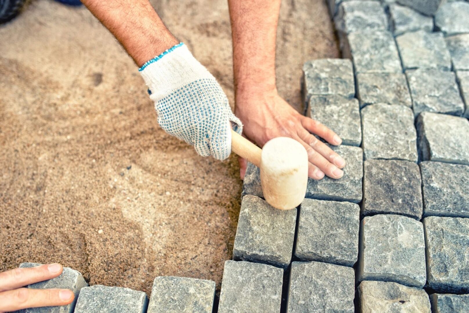 A person with gloves on holding a hammer