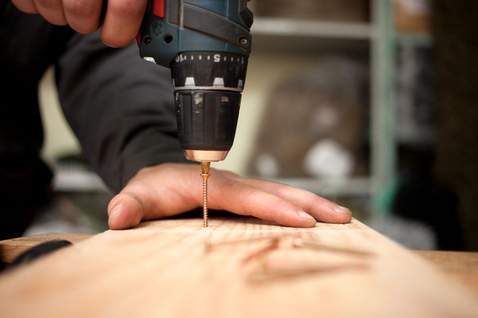 A person using a drill to make something.