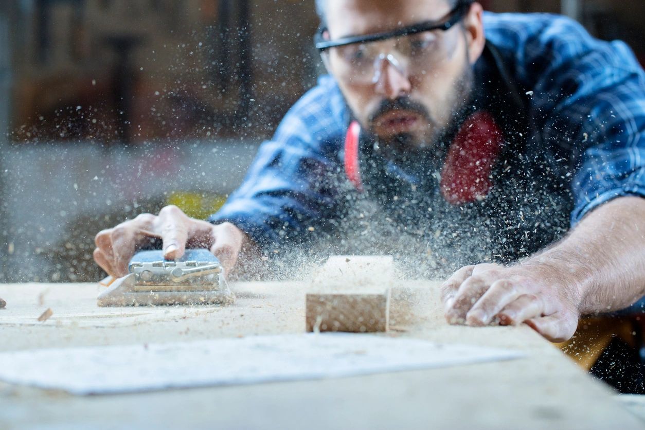 A man sanding on top of a table.